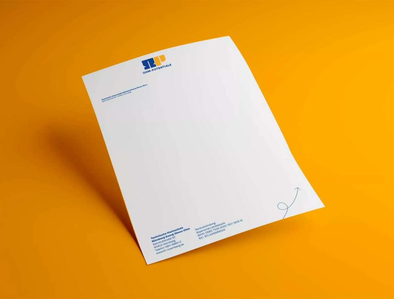 Ein Blatt Briefpapier mit blauen und gelben Markenelementen und Kontaktinformationen, die schräg auf einem orangefarbenen Hintergrund angeordnet sind. Das Papier ist oben mit einem Logo und unten rechts mit einem dekorativen Pfeil versehen.