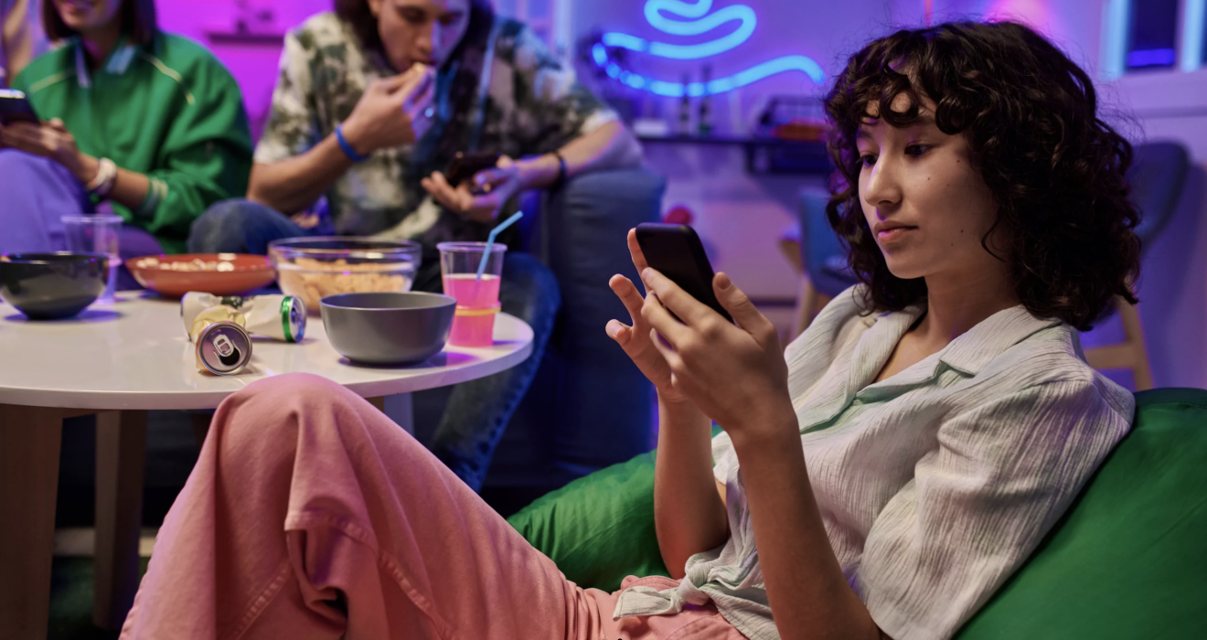 Junge Frau auf einer Party am Handy